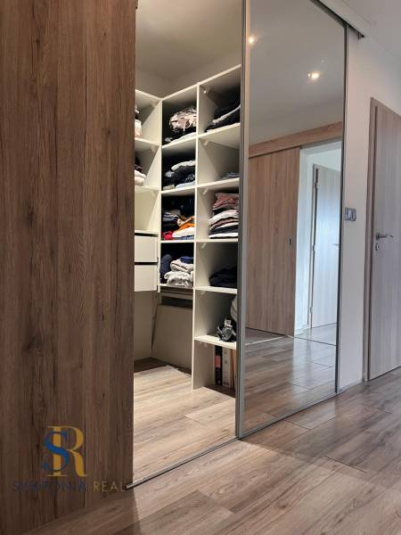 Rodinný dom v obci Dubová s 920m2 rozsiahlym pozemkom  - Vstavaná skriňa s posuvnými dverami a podlaha s dreveným dekorom v rodinnom dome.