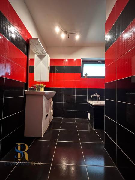 Rodinný dom v obci Dubová s 920m2 rozsiahlym pozemkom  - Čierno-červená kúpeľňa v rodinnom dome so zrkadlom a vaňou, výrazná kombinácia obkladov.