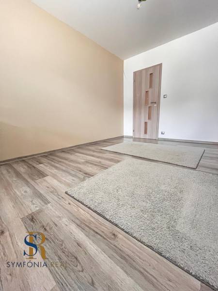 Rodinný dom v obci Dubová s 920m2 rozsiahlym pozemkom  - Miestnosť v rodinnom dome s podlahou s dreveným dekorom a svetlými stenami.