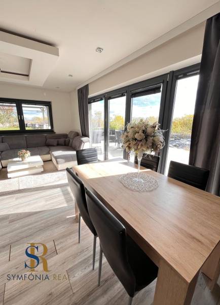 Rodinný dom v obci Dubová s 920m2 rozsiahlym pozemkom  - Obývačka rodinného domu s podlahou s dreveným dekorom a komfortným sedením.