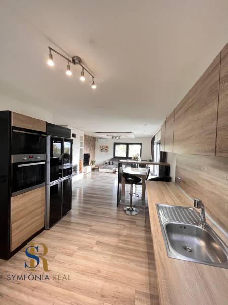 Rodinný dom v obci Dubová s 920m2 rozsiahlym pozemkom  - Kuchyňa v rodinnom dome s podlahou s dreveným dekorom a praktickým sedením.