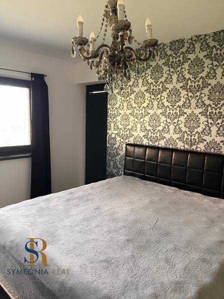 Rodinný dom v obci Dubová s 920m2 rozsiahlym pozemkom  - Spálňa v rodinnom dome s dekoratívnou tapetou a lustrom. Symfónia interiérového dizajnu.