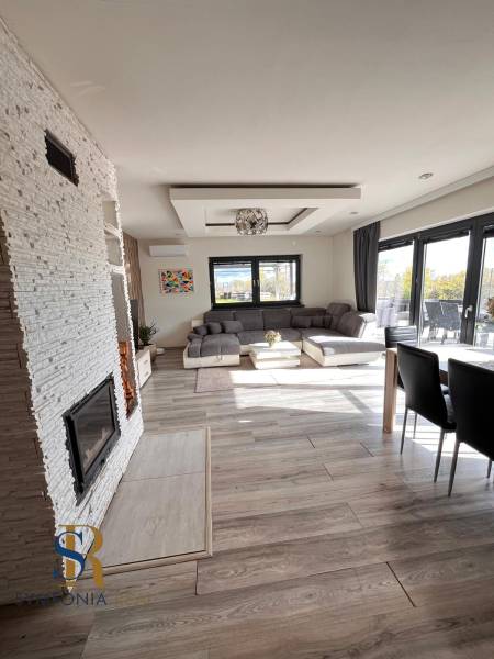 Rodinný dom v obci Dubová s 920m2 rozsiahlym pozemkom  - Interiér rodinného domu s pohovkou, krbom a podlahou s dreveným dekorom.