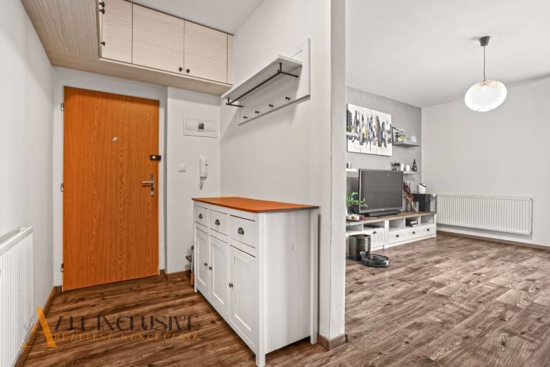 NA PREDAJ 2-IZBOVÝ BYT S 2 BALKÓNMI, DUNAJSKÁ STREDA - Vstupná chodba v 2-izbovom byte s podlahou s dreveným dekorom a bielym nábytkom.