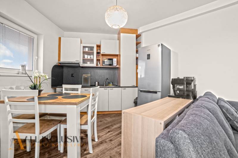 NA PREDAJ 2-IZBOVÝ BYT S 2 BALKÓNMI, DUNAJSKÁ STREDA - Kuchyňa v 2-izbovom byte s podlahou s dreveným dekorom a jedálenským stolom.