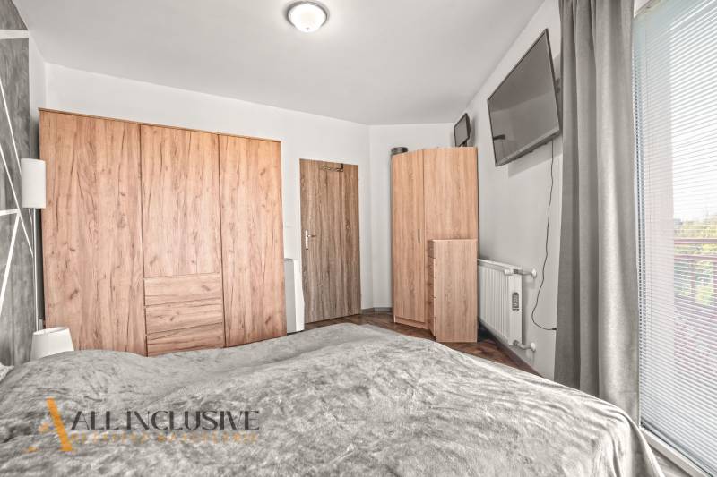 NA PREDAJ 2-IZBOVÝ BYT S 2 BALKÓNMI, DUNAJSKÁ STREDA - Spálňa v 2-izbovom byte s podlahou s dreveným dekorom a šatníkovými skriňami.