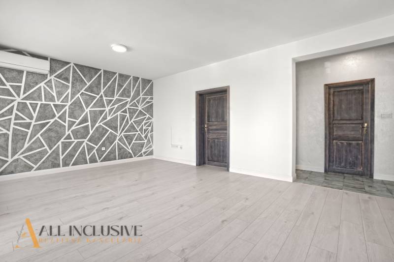 PRENAJATÉ | NA PRENÁJOM 2x 2-IZBOVÉ BYTY S TERASOU,DUNAJSKÁ STREDA - Obývacia izba s podlahou s dreveným dekorom a geometrickou stenou v 2-izbovom byte.