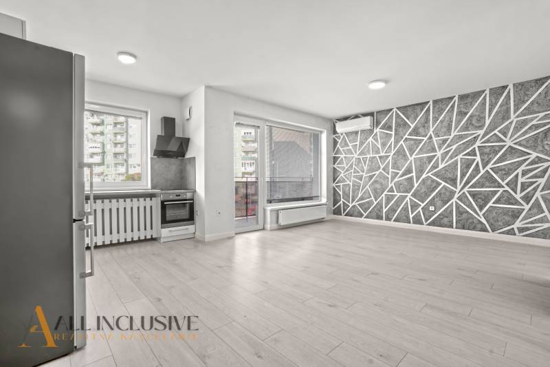 PRENAJATÉ | NA PRENÁJOM 2x 2-IZBOVÉ BYTY S TERASOU,DUNAJSKÁ STREDA - Kuchyňa a obývačka v 2-izbovom byte s podlahou s dreveným dekorom a geometrickou stenou.