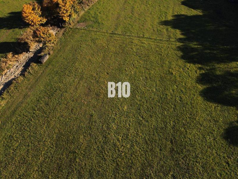 VOĽNÉ  2 zo 4 - Slnečné pozemky Petrovice-Setechov - Trávnatý pozemok na bývanie v Petroviciach, obklopený zeleňou a stromami.