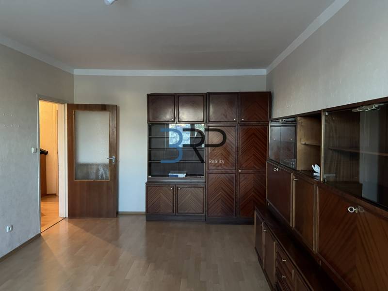 REZERVOVANÝ! Na predaj 2izbový byt v meste Senica - Obývacia izba v 2-izbovom byte s veľkou drevenou obývačkovou súpravou a podlahou s dreveným dekorom.