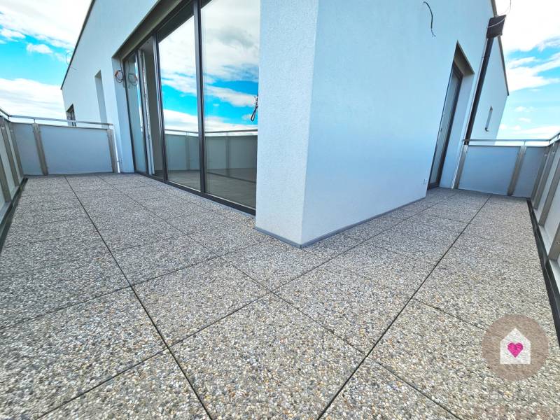 3i. BYT S VLASTNÝM TEP. ČERPADLOM + KLIMATIZÁCIA A EXTERIÉROVÉ ŽALÚZIE - Terasové dlaždice na balkóne 3-izbového bytu s presklenými dverami.