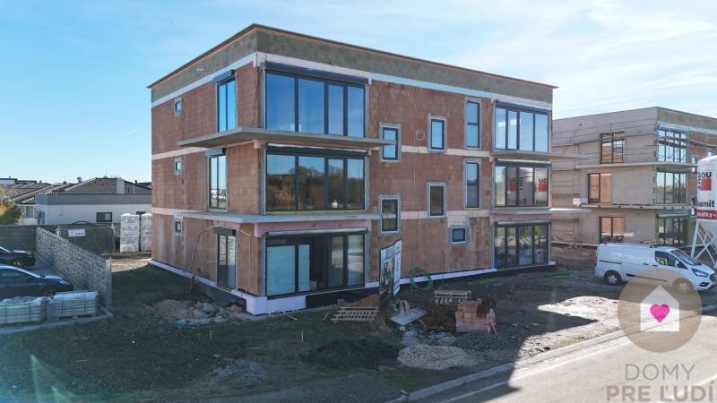 3i. BYT S VLASTNÝM TEP. ČERPADLOM + KLIMATIZÁCIA A EXTERIÉROVÉ ŽALÚZIE - Novostavba na Dúhovej ulici v Slovenskom Grobe so zasklenými stenami a parkoviskom.