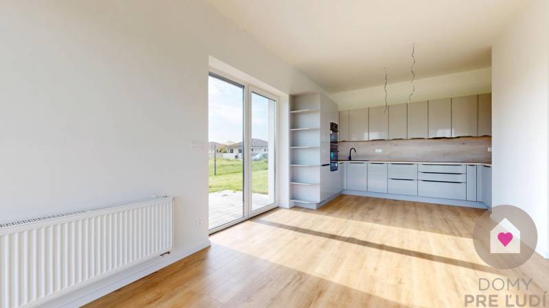 3i. BYT SO ZÁHRADOU +TEP. ČERPADLO, KLIMATIZÁCIA A ŽALÚZIE V CENE - Kuchyňa a obývacia časť v 3-izbovom byte s veľkými oknami a výhľadom na zeleň.