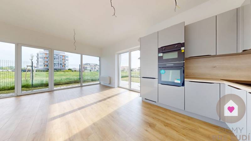 3i. BYT SO ZÁHRADOU +TEP. ČERPADLO, KLIMATIZÁCIA A ŽALÚZIE V CENE - O presvetlenej kuchyni v 3-izbovom byte s drevenou podlahou a veľkými oknami.