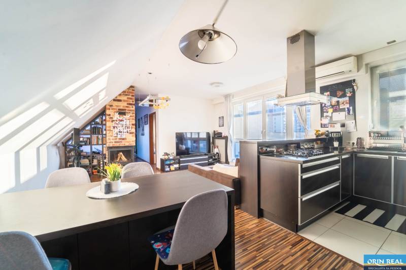 Rezervovaný!!! 2izb + terasa byt Vajanského Modra 93,8m2 - Kuchyňa s televízorom, krbom a podlahou s dreveným dekorom v 2-izbovom byte.