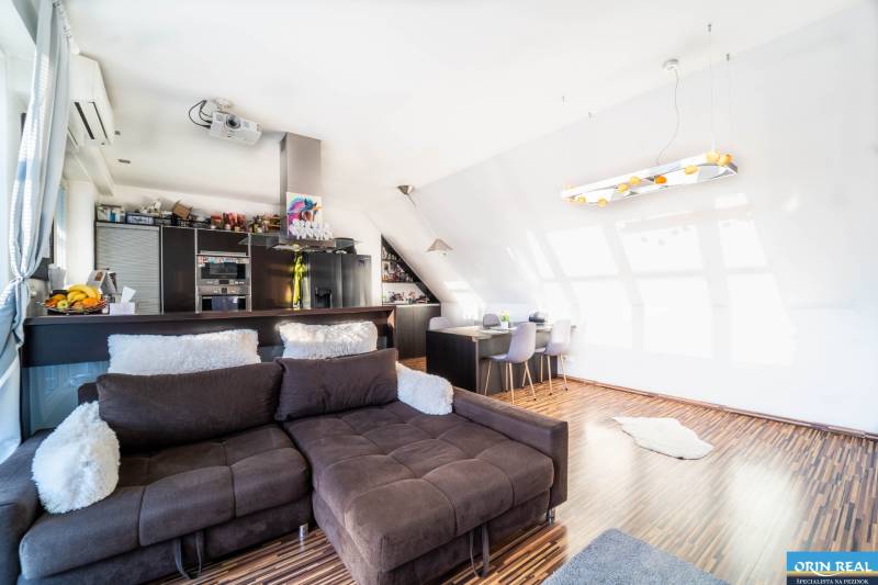 Rezervovaný!!! 2izb + terasa byt Vajanského Modra 93,8m2 - Obývacia izba s kuchynským kútom, pohovkou a podlahou s dreveným dekorom, 2-izbový byt.