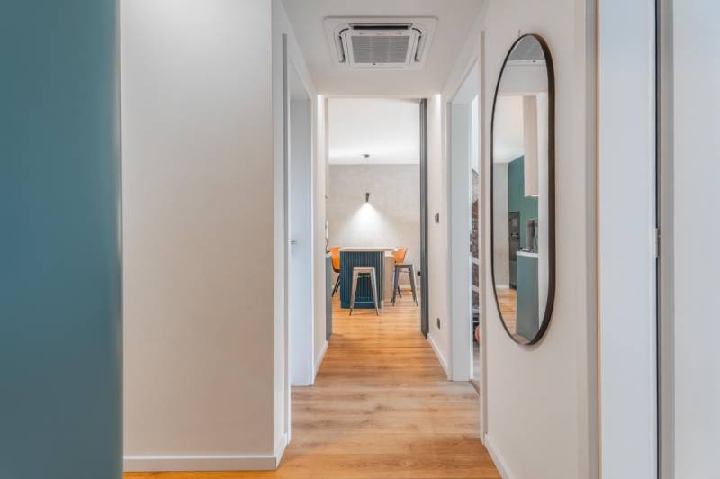 PRENÁJOM 3 izbový byt s predzáhradkou, BORY PROMENÁDA - Interiér 3-izbového bytu s podlahou s dreveným dekorom a okrúhlym zrkadlom.