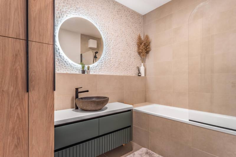 PRENÁJOM 3 izbový byt s predzáhradkou, BORY PROMENÁDA - Kúpeľňa v 3-izbovom byte so vzorovanou stenou, okrúhlym zrkadlom a vaňou.