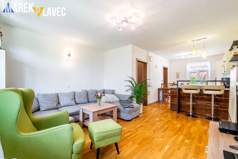 Na predaj: Rodinný dom Slatinské Lazy s očarujúcou atmosférou - Obývacia izba rodinného domu s podlahou s dreveným dekorom, veľkou sedacou súpravou a kuchynským pultom.