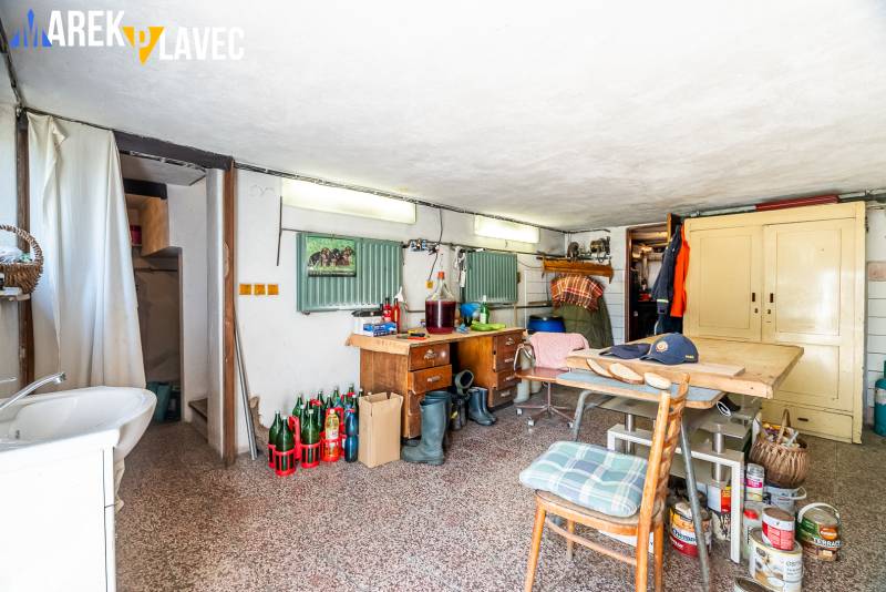 Na predaj: Rodinný dom Slatinské Lazy s očarujúcou atmosférou - Dielňa v rodinnom dome s náradím, stolom, skrinkou a stoličkou.