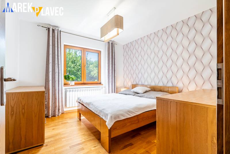 Na predaj: Rodinný dom Slatinské Lazy s očarujúcou atmosférou - Spálňa v rodinnom dome s podlahou s dreveným dekorom a vlnitou tapetou.