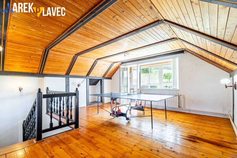 Na predaj: Rodinný dom Slatinské Lazy s očarujúcou atmosférou - Priestor s pingpongovým stolom a stropom z dreveného obkladu v rodinnom dome.