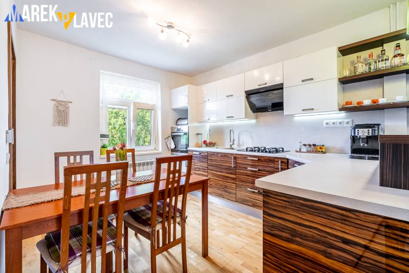 Na predaj: Rodinný dom Slatinské Lazy s očarujúcou atmosférou - Kuchyňa v rodinnom dome s jedálenským stolom a podlahou s dreveným dekorom.
