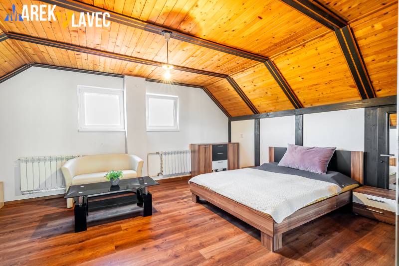 Na predaj: Rodinný dom Slatinské Lazy s očarujúcou atmosférou - Podkrovná izba v rodinnom dome s podlahou z dreveným dekorom a dreveným stropom.