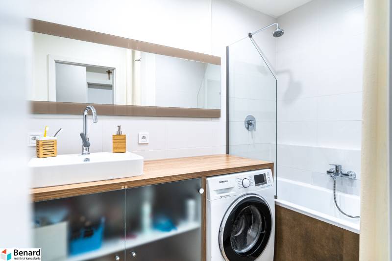 Na prenájom štýlový  3 - izb. byt  (Košice - Sever) - Kúpeľňa s umývadlom, práčkou a vaňou v 3-izbovom byte, podlaha s dreveným dekorom.