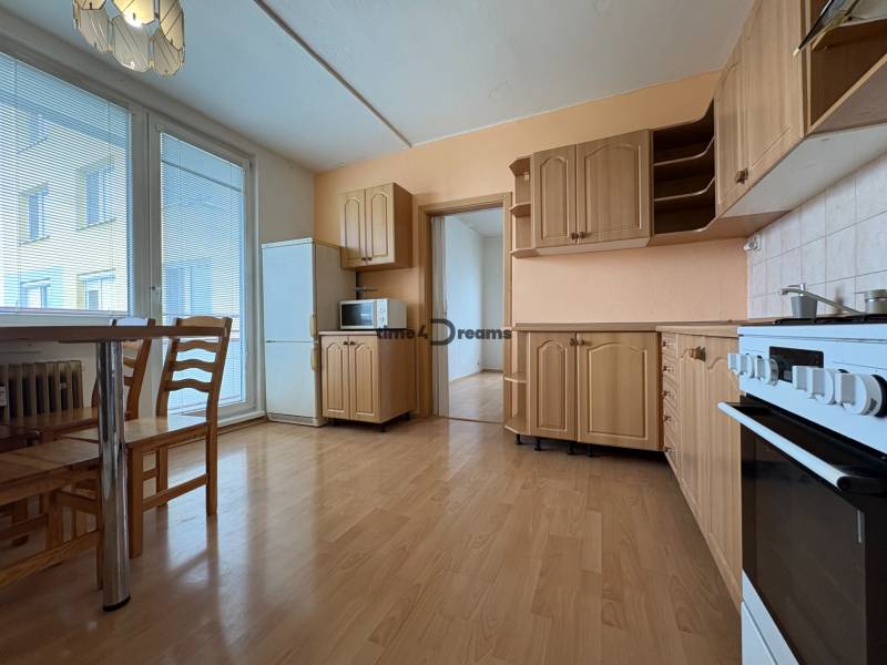 Na predaj: 3 izb.byt + 2x balkon + kumbál - Kuchyňa v 3-izbovom byte s dreveným nábytkom, sporákom a mikrovlnkou.