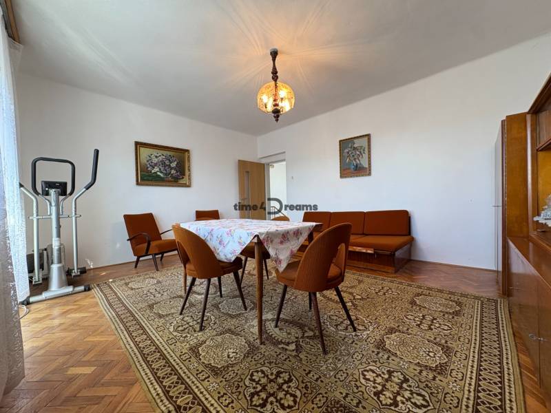 Na predaj: Rodinný dom v meste Levice - Obývacia izba v rodinnom dome s podlahou s dreveným dekorom, kobercom a vintage nábytkom.