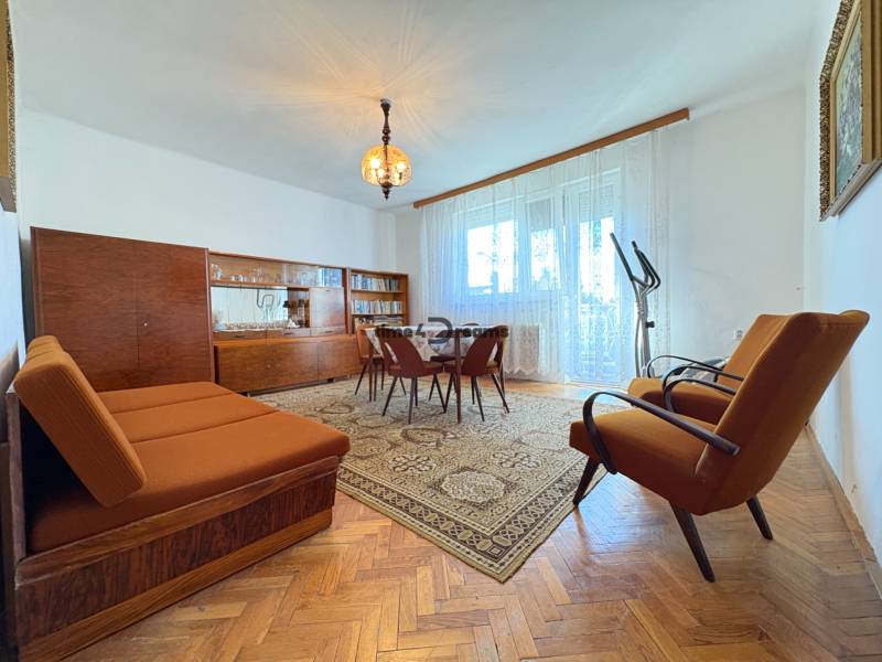 Na predaj: Rodinný dom v meste Levice - Obývačka rodinného domu s retro nábytkom a podlahou s dreveným dekorom.