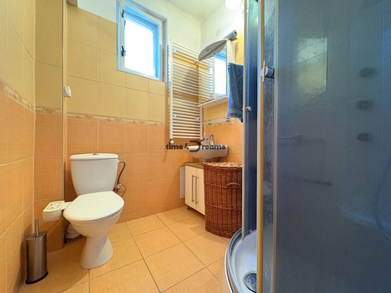 Na predaj: Rodinný dom v meste Levice - Kúpeľňa v rodinnom dome s toaletou, sprchovým kútom a oknom.