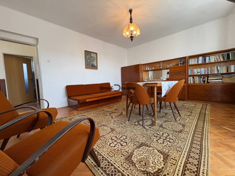 Na predaj: Rodinný dom v meste Levice - Obývacia izba v rodinnom dome s hnedým nábytkom a kobercom na podlahe s dreveným dekorom.