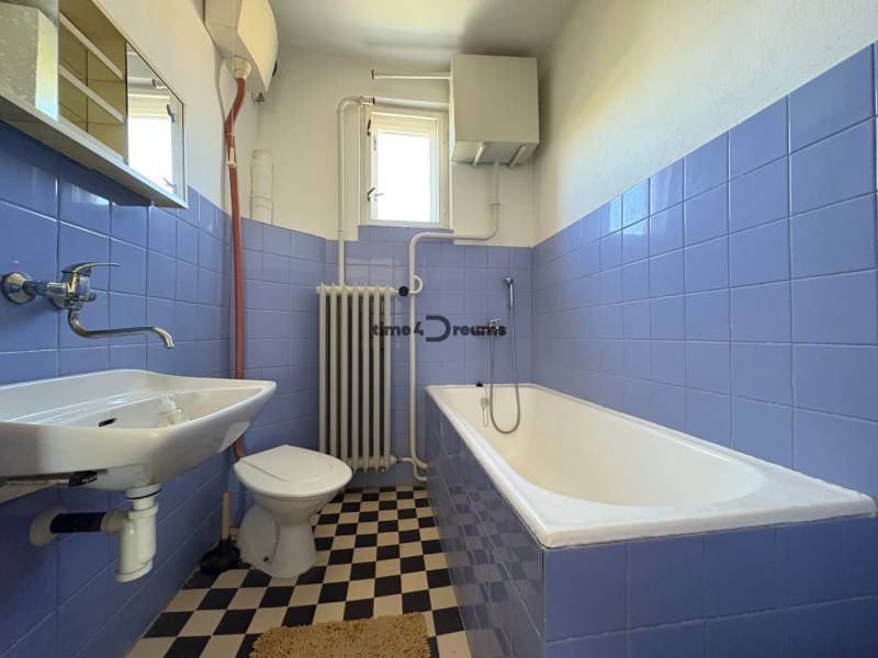 Na predaj: Rodinný dom v meste Levice - Kúpeľňa v rodinnom dome s modrými obkladačkami, vaňou a umývadlom.