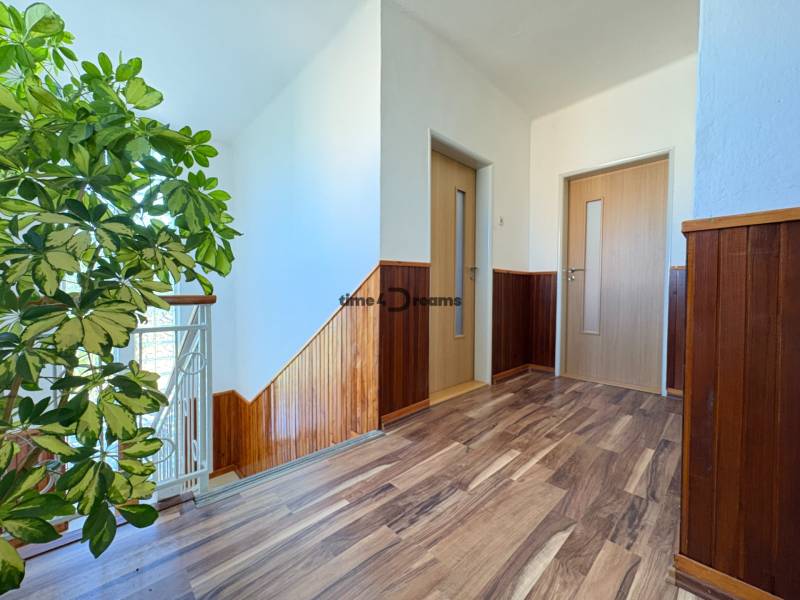 Na predaj: Rodinný dom v meste Levice - Chodba v rodinnom dome s podlahou s dreveným dekorom a rastlinou.