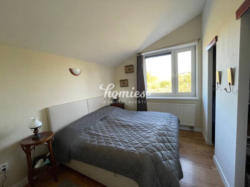 PREDAJ krásny 6 izb. rod. dom prepojený s prírodou - Spálňa v rodinnom dome s posteľou a podlahou s dreveným dekorom.