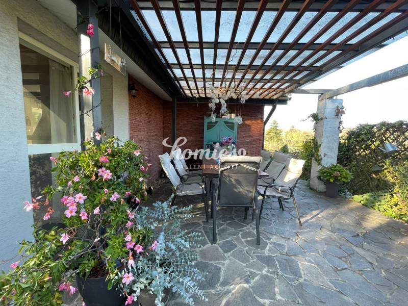 PREDAJ krásny 6 izb. rod. dom prepojený s prírodou - Terasa rodinného domu v Lehote s kvetmi a posedením pod pergolou.