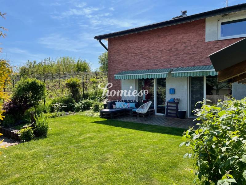 PREDAJ krásny 6 izb. rod. dom prepojený s prírodou - Rodinný dom v Lehote s terasou, trávnikom a bujnou záhradou pod modrou oblohou.