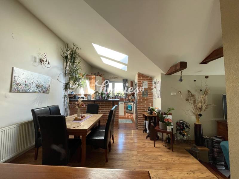 PREDAJ krásny 6 izb. rod. dom prepojený s prírodou - Jedáleň s podlahou s dreveným dekorom, stolom a čiernymi stoličkami v rodinnom dome.