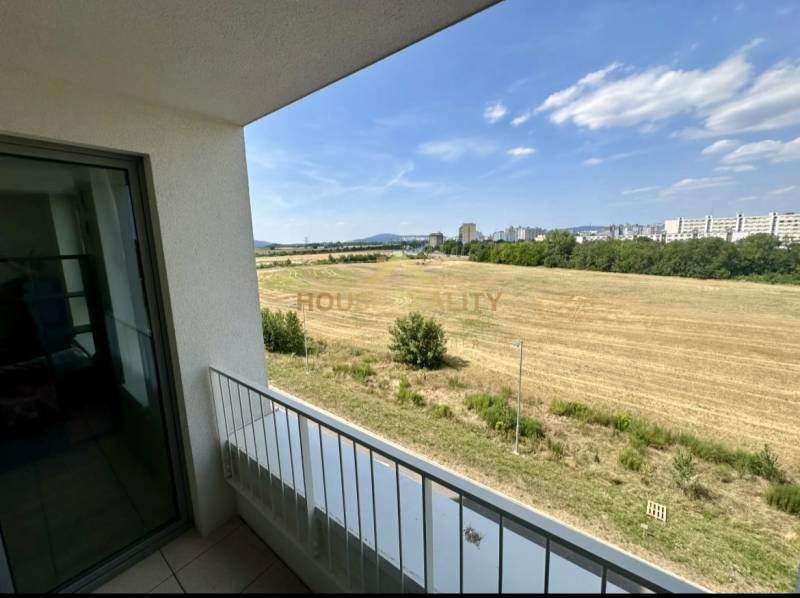 Nový 2 izbový byt SLNEČNICE, Labutia ulica, Bratislava V. Petržalka - Výhľad z balkóna na polia a mesto v Bratislave na ulici Labutia, Petržalka.