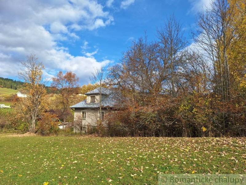 Dom v pôvodnom stave na krásnom pozemku (2130m2) v malej dedinke na Li - Rodinný dom v Liptovských Beharovciach obklopený jesennými stromami a zelenou lúkou.