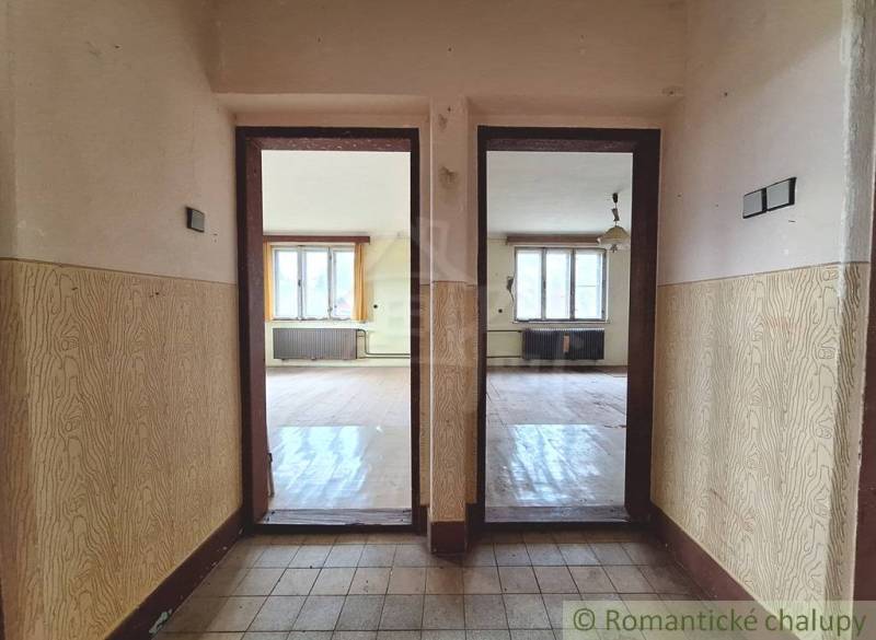 Dom v pôvodnom stave na krásnom pozemku (2130m2) v malej dedinke na Li - Interiér rodinného domu s podlahou s dreveným dekorom a dvoma miestnosťami.