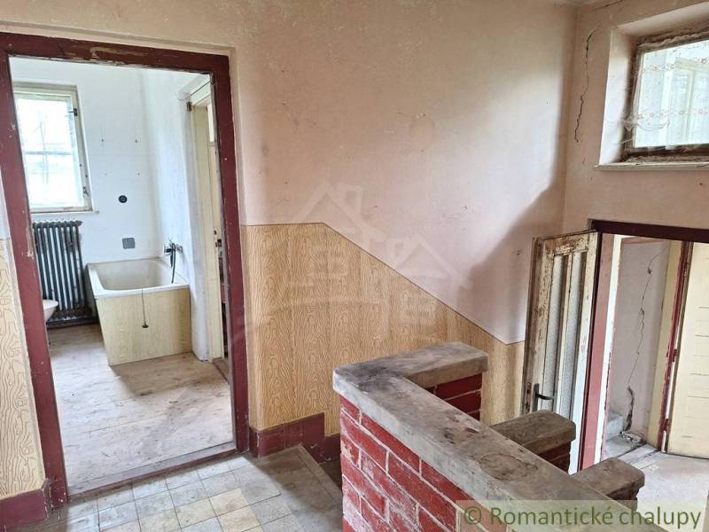 Dom v pôvodnom stave na krásnom pozemku (2130m2) v malej dedinke na Li - Interiér rodinného domu s obkladom, starou vaňou a podlahou s dreveným dekorom.