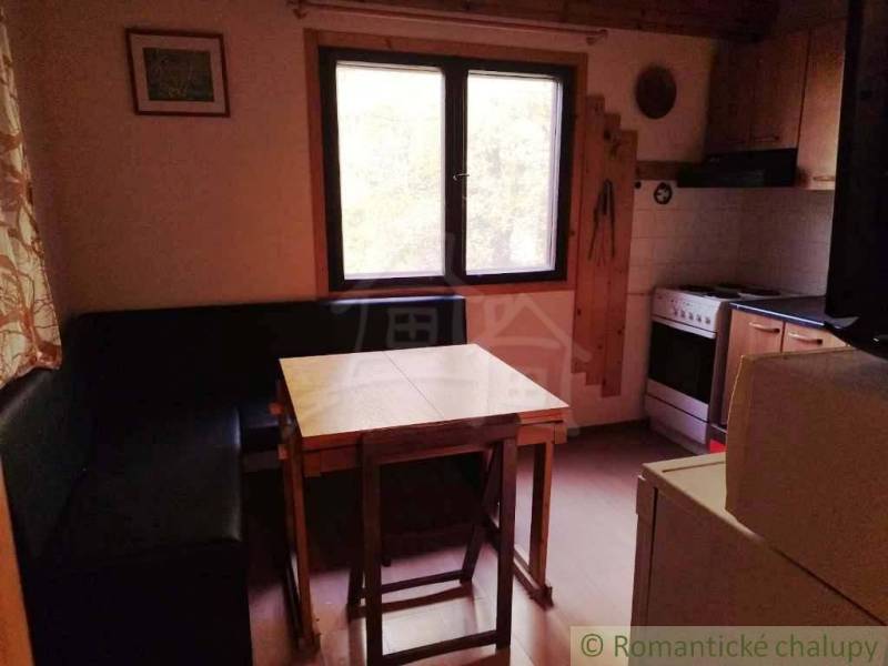 Chata nad kúpeľmi Dudince s vlastným pozemkom - Kuchynka v chate s rohovou lavicou, stolom a sporákom.