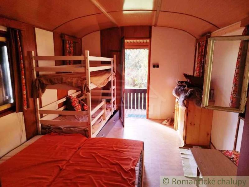 Chata nad kúpeľmi Dudince s vlastným pozemkom - Interiér chaty so štyrmi posteľami a presvetleným výhľadom na terasu.