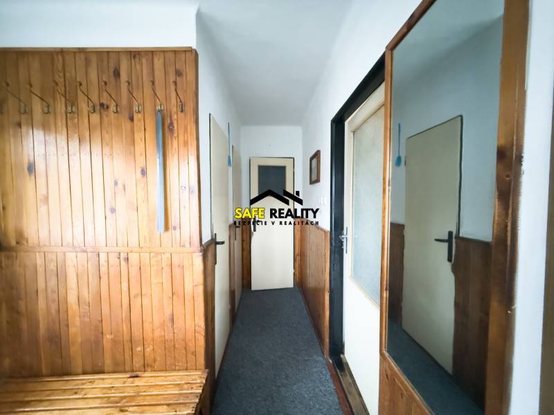 Rodinný dom s veľkým pozemkom v obci Sklené,  - Vstupná chodba v rodinnom dome s dreveným obkladom a zrkadlom na stene.