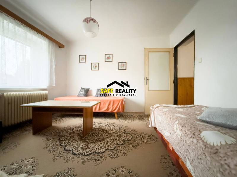 Rodinný dom s veľkým pozemkom v obci Sklené,  - Obývacia izba v rodinnom dome s dvoma pohovkami a stolom na koberci.