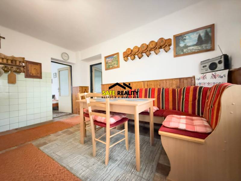 Rodinný dom s veľkým pozemkom v obci Sklené,  - Jedáleň rodinného domu s rohovou lavicou, dreveným dekorom a dekoratívnymi obrázkami na stene.