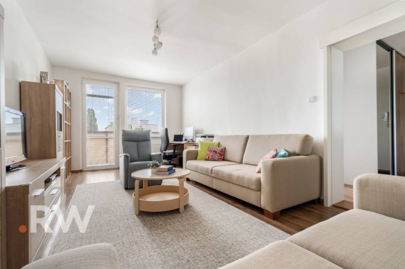 REWIN I Priestranný 3 izbový byt v tichej lokalite Senca - Obývacia izba s pohovkou, kreslom a pracovným stolom v 3-izbovom byte.